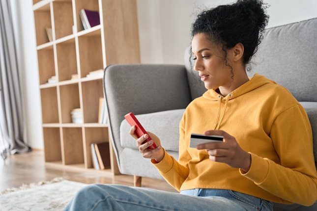 A young consumer checking financial details on her phone.