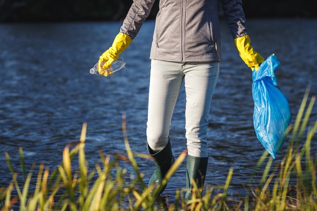 An environmentalist collecting plastic bottles from the watershed.